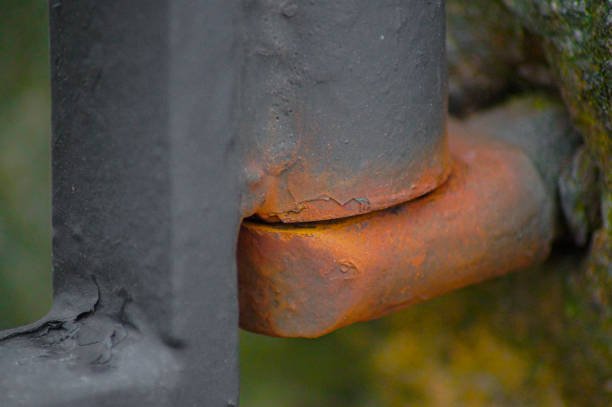 Close-up of a rusty metal hinge on an iron gate, showing signs of corrosion and the need for iron door repair.