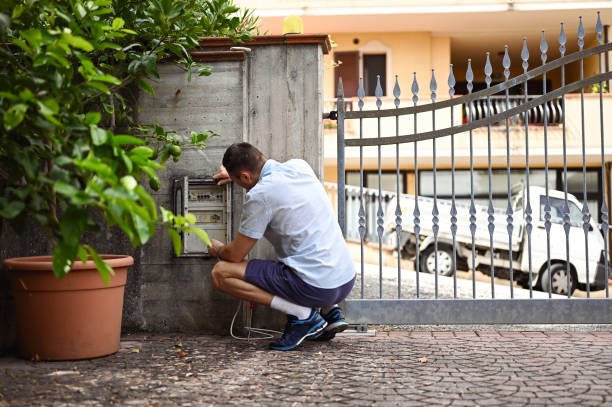 A worker installing a security fence in Los Angeles County, featuring durable metal mesh for enhanced home protection.